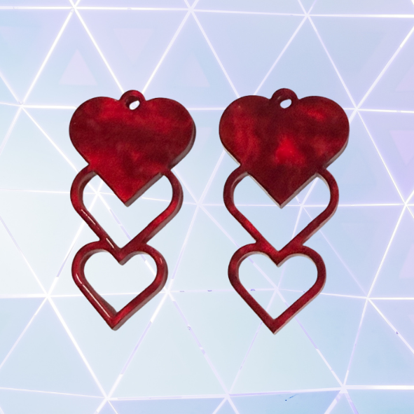 Red heart-shaped earrings on a geometric patterned background