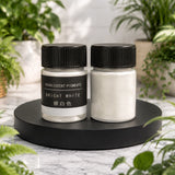 Two jars of pearlescent pigments on a black stand with plants in the background