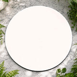 Round white plate on a marble surface with greenery
