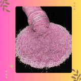 Pink glitter being poured from a container onto a black surface with a colorful border.