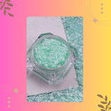 Green glittery powder in a clear jar on a colorful background