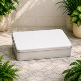 Silver rectangular box on a marble surface with plants around