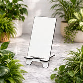 Phone stand on a marble surface with plants around