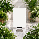 White rectangular air purifier surrounded by potted plants on a marble floor.