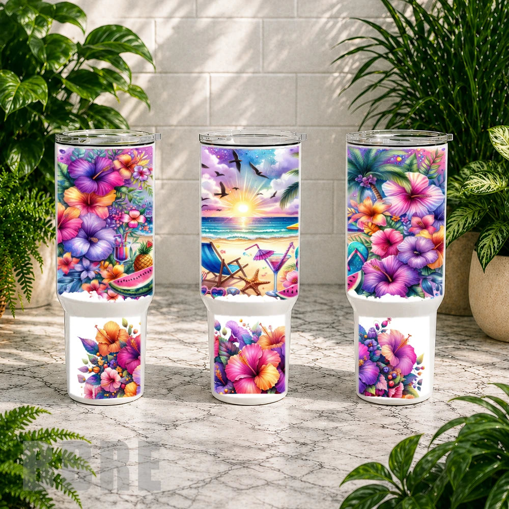 Three colorful tumblers with floral and beach designs on a marble surface with plants in the background.