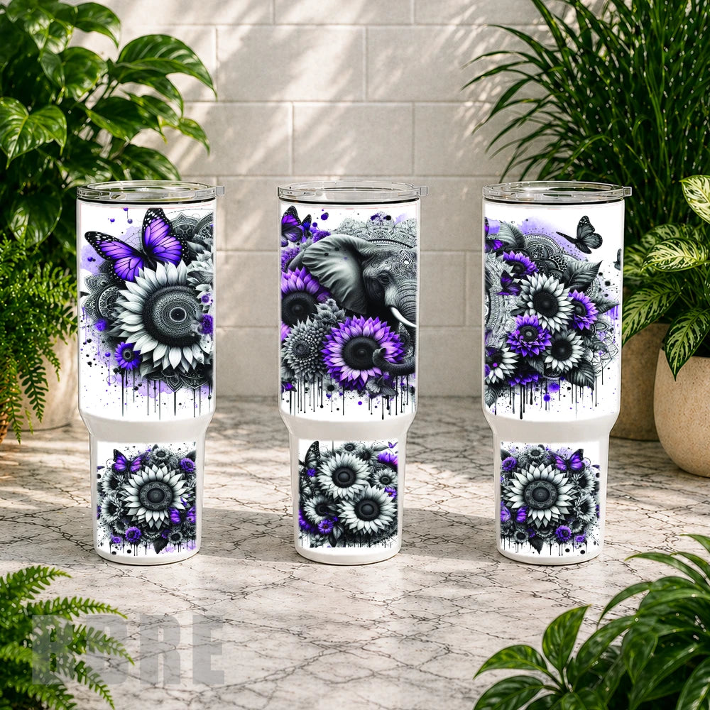 Three tumblers with floral and butterfly design on a marble surface with plants in the background