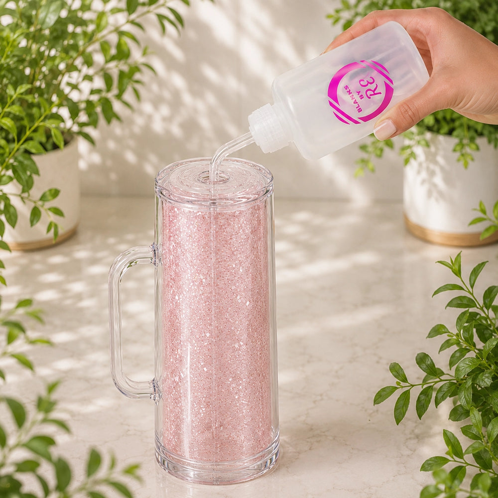 Hand pouring a pink liquid into a clear mug with plants in the background