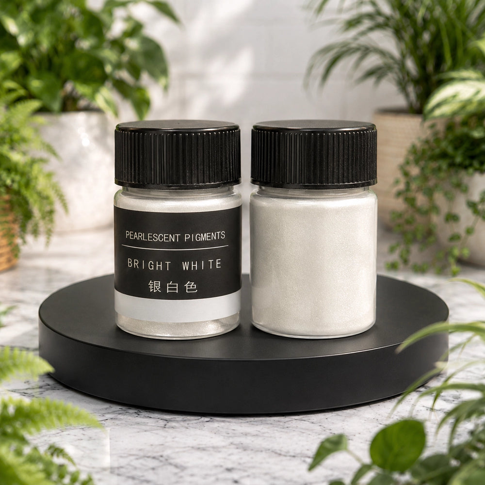 Two jars of pearlescent pigments on a black stand with plants in the background