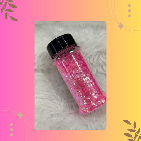 Pink glitter jar with black lid on a textured surface with decorative elements.