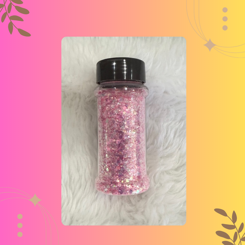 Pink glitter in a black-lidded jar on a textured white surface with a colorful border.