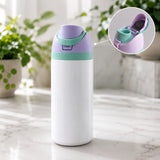 White water bottle with purple and green accents on a marble surface with plants in the background