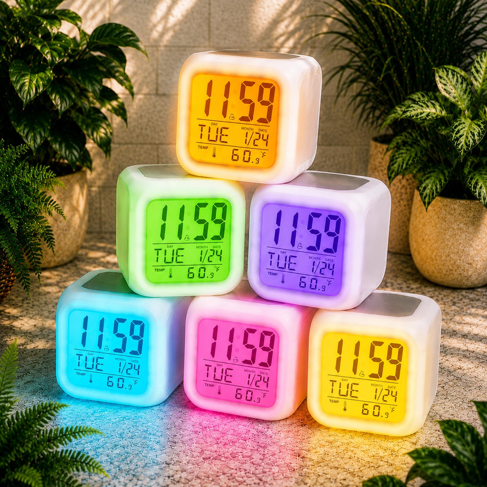 Colorful digital alarm clocks stacked on a surface with plants in the background