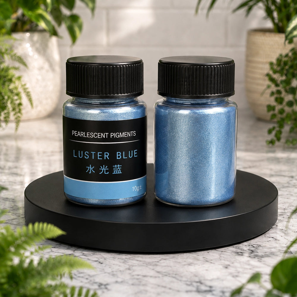 Two containers of luster blue pigments on a black stand with plants in the background.