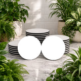 Set of black and white striped bowls on a marble surface with plants around