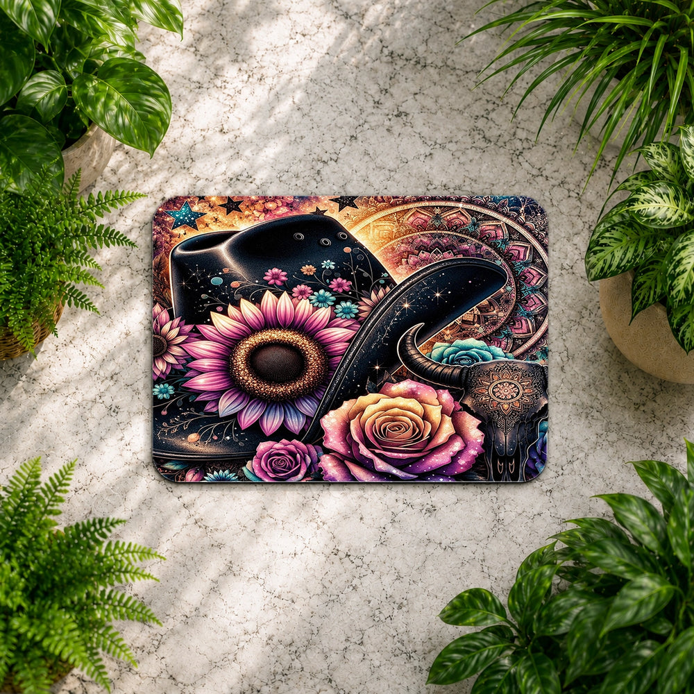 Decorative mat with floral and snake design on a textured surface surrounded by plants