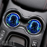 Car cup holder with blue and black horse design coasters on a gray dashboard.