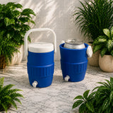 Two blue coolers with white handles and spouts on a marble surface with plants around.