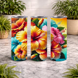 Three colorful tumblers with floral designs on a marble surface.