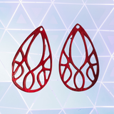 Red teardrop-shaped earrings on a geometric patterned background