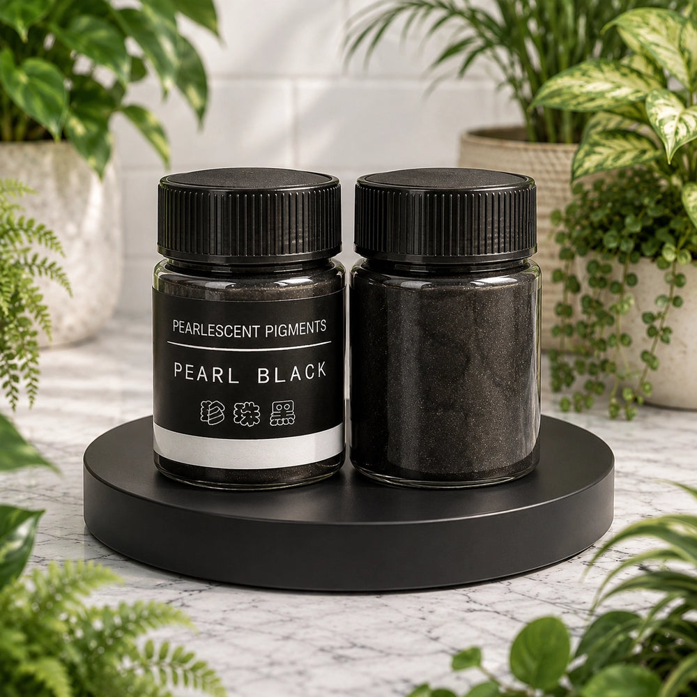 Two jars of pearl black pigment on a black stand with plants in the background