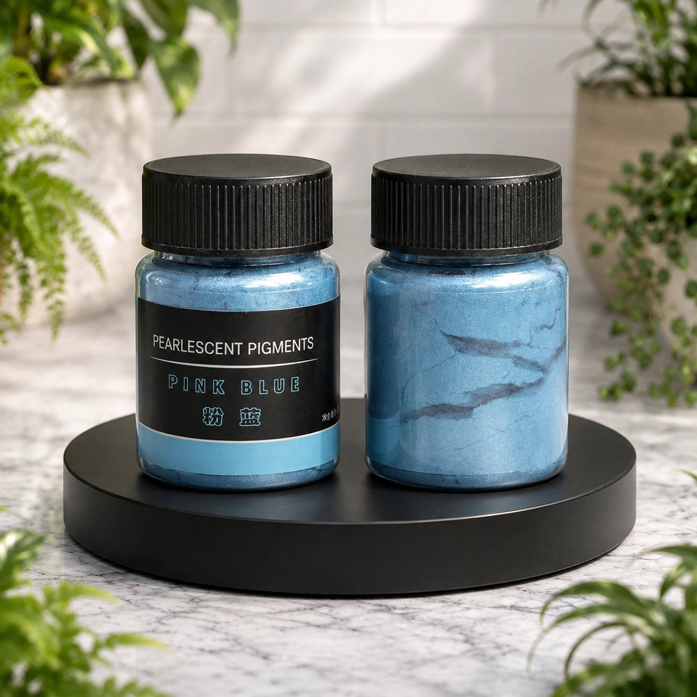 Two jars of pearlescent pigments labeled 'Pink Blue' on a black stand with a blurred natural background.