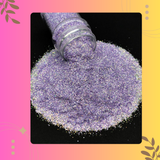 Purple glitter spilling out of a bottle on a black background with decorative elements.