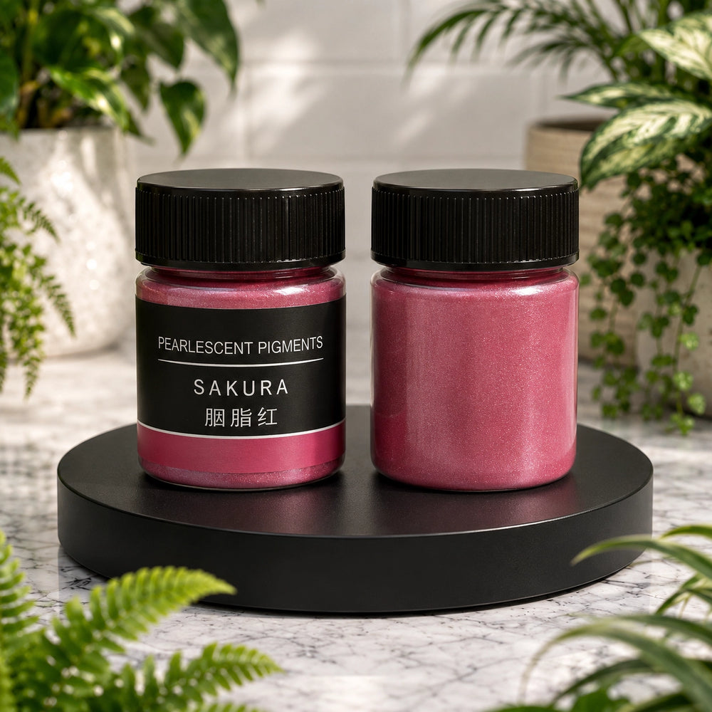 Two jars of sakura pearlcent pigments on a black stand with plants in the background