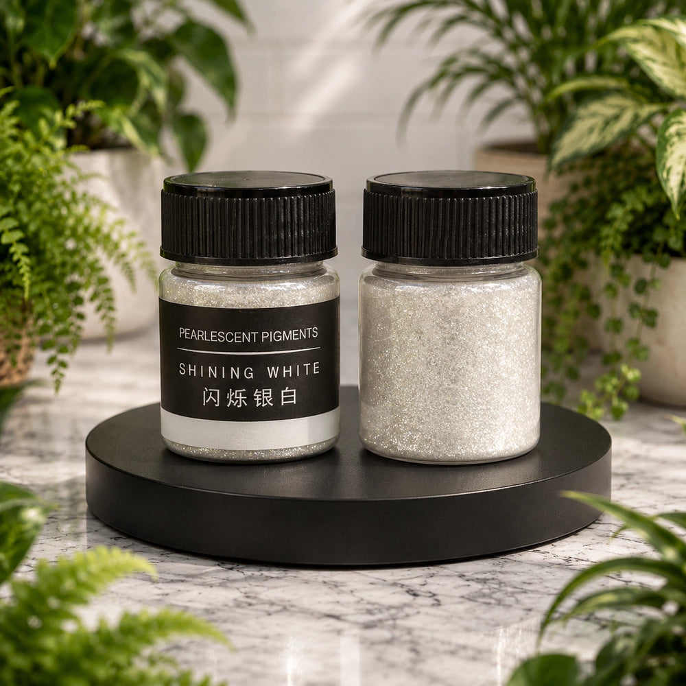 Two jars of pearlescent pigments on a black stand with plants in the background
