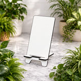 Phone stand on a marble surface with plants around