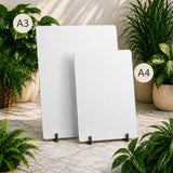 Two white boards on stands with plants in the background