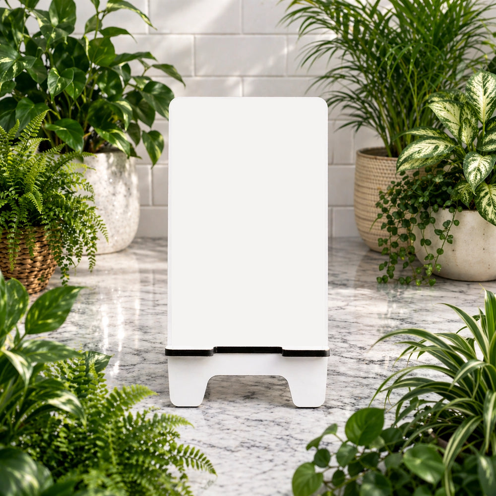 White rectangular air purifier surrounded by potted plants on a marble floor.