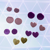 Purple heart-shaped and round earrings on a geometric patterned background