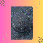 Black glitter in a small container on a colorful background