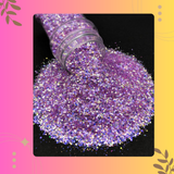 Purple glitter spilling out of a bottle on a black background with decorative elements.