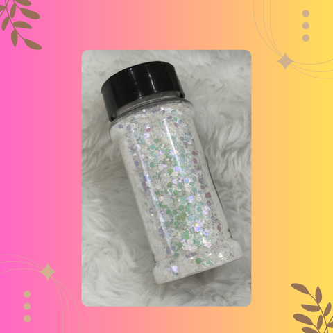 Jar of glitter with a black lid on a textured surface with decorative elements.