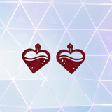 Red heart-shaped earrings on a geometric patterned background