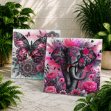 Two decorative wall clocks with butterfly and elephant designs on a marble surface with plants in the background.
