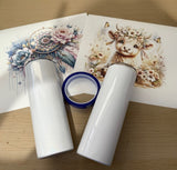 Two rolls of white vinyl with a printed design of a cow and flowers on a wooden surface.